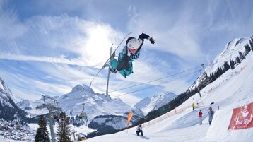 Freestylers in the Snowpark Lech with a view of the Omeshorn.