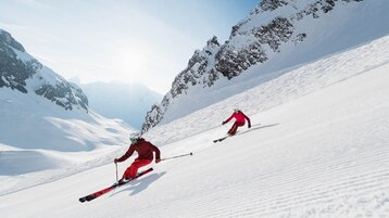 Skiers in Zürser Täli on a freshly prepared slope
