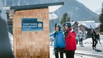 Skiers picking up ski tickets at a pickup box