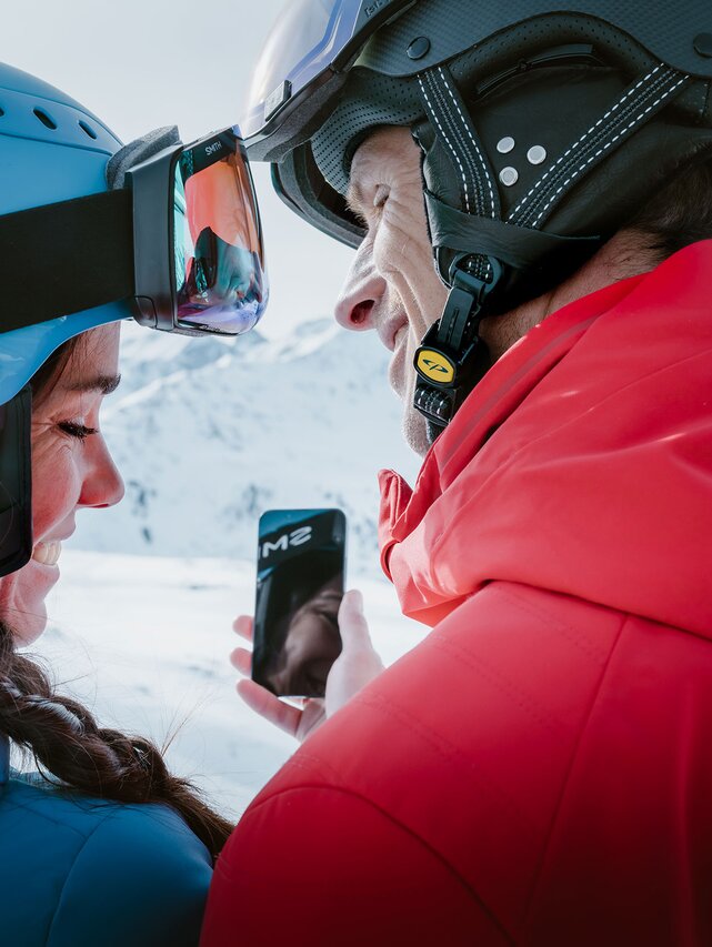 Skiers with the Ski Arlberg App on their smartphone