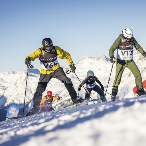Vier Skifahrer bei einem Rennen am verschneiten Arlberg.