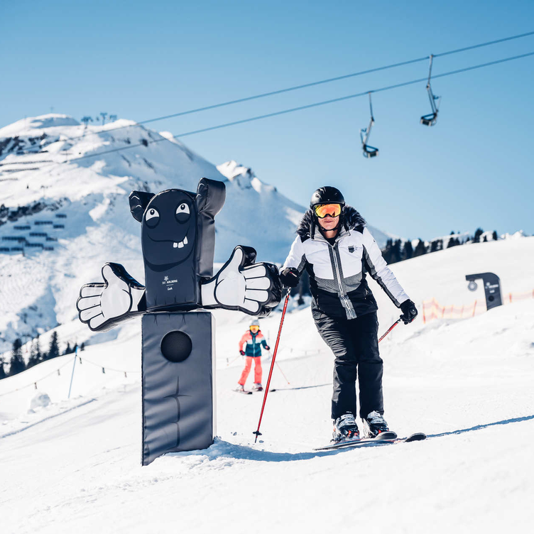 Skier next to a funny black and white obstacle on the slope.