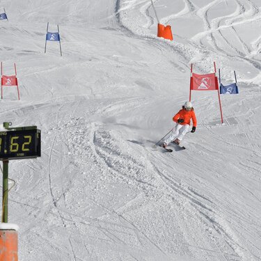 Skier on a slalom course with a digital stopwatch displaying his time.