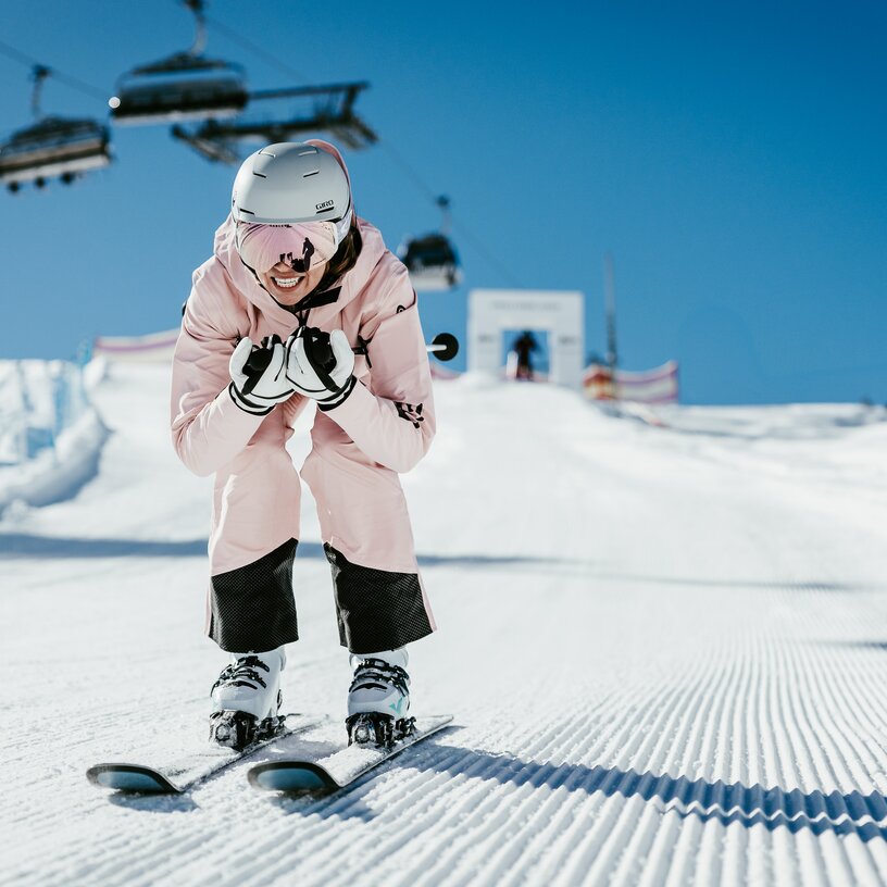 A person in pink ski gear racing down a slope.