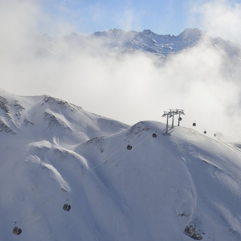 Seilbahnen fahren über schneebedeckte Berge in Lech Zürs.