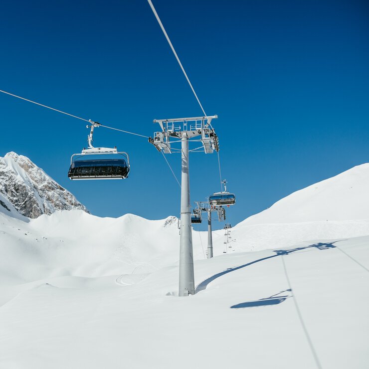 Chairlift over snowy alpine landscape at Lech Zürs ski resort.