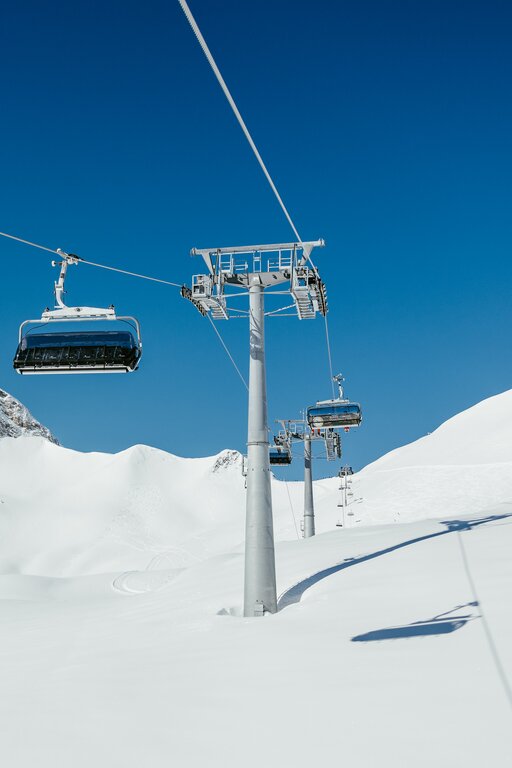 Chairlift over snowy alpine landscape at Lech Zürs ski resort.