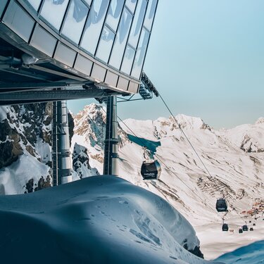 Bergstation für Gondelbahn über schneebedeckten Bergen in der Skiregion Lech Zürs.