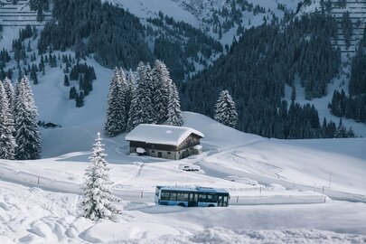 Schneebedeckte Landschaft mit Bus und Hütte in der Skiregion Lech Zürs.