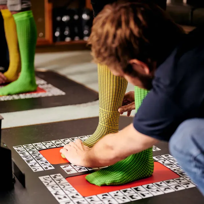 Feet in bright-coloured socks are being prepared for a 3D scan.
