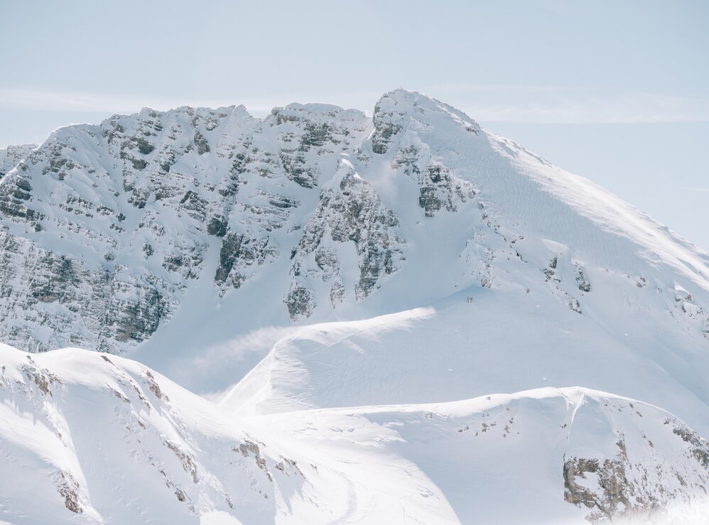 Verschneiter Berg mit felsigen Gipfeln, sonniger Tag