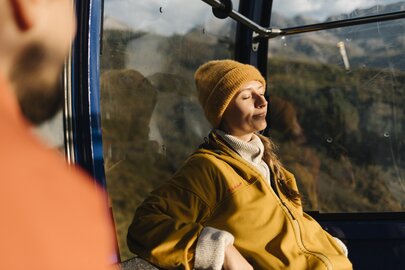 Person relaxing in cable car enjoying the sunshine.