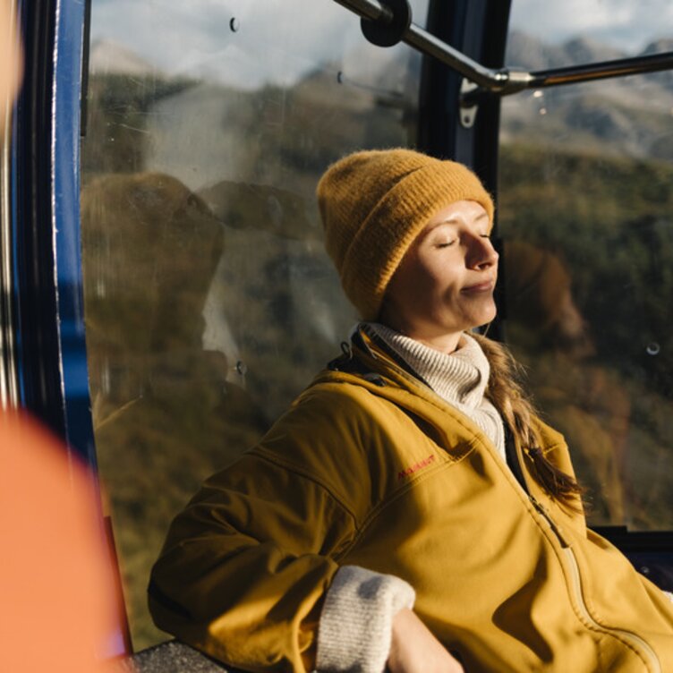 Person relaxing in cable car enjoying the sunshine.