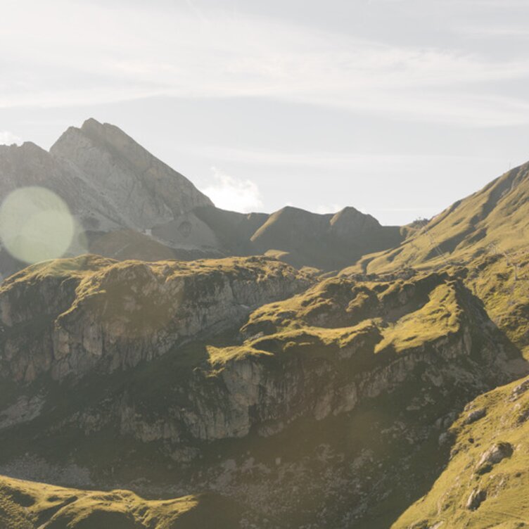 Green hills and mountains in sunlight.