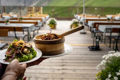 Traditional food being served on an Alpine sun terrace with mountain view.