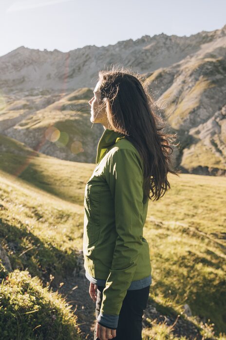 Woman enjoying the view on a sunny mountain path.