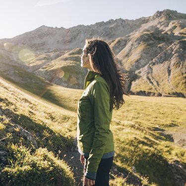 Woman enjoying the view on a sunny mountain path.