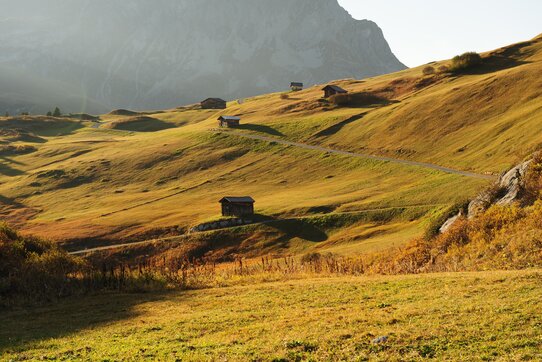Gentle hills and huts in an autumn mountain landscape, part of 'The Green Ring'.
