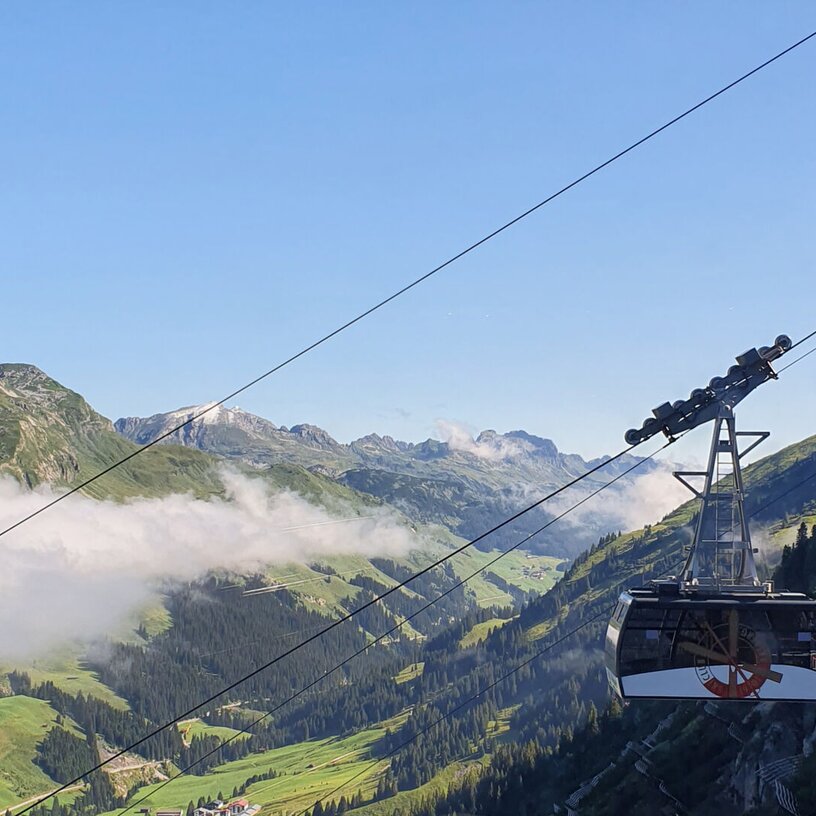 View of a cable car in the mountains with clear skies.