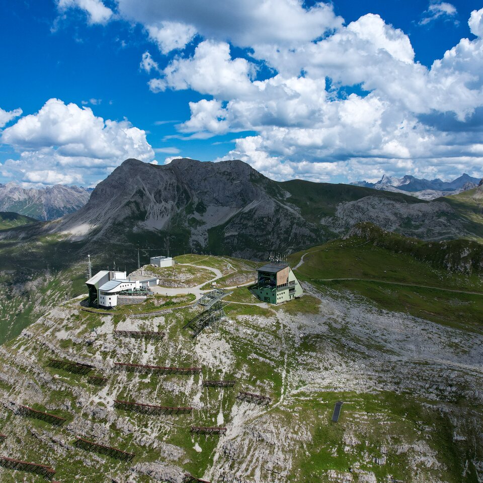 Mountain station at Rüfikopf panoramic mountain under blue sky.