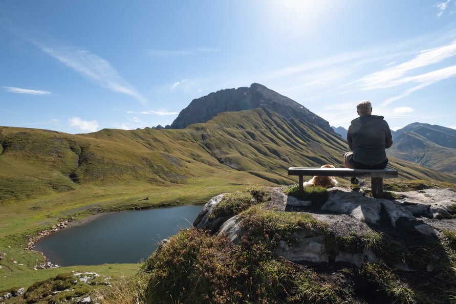 Person enjoying the view of Rüfikopf panoramic mountain and a mountain lake.