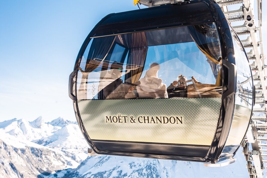 Moët & Chandon Champagner-Gondel mit Panoramablick auf verschneite Berge.