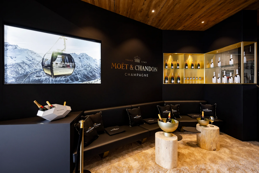 Elegante Champagner Lounge mit Moët & Chandon Dekor und Bergblick.