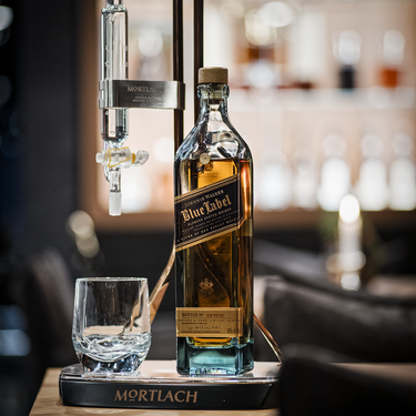 Eine Flasche Johnnie Walker Blue Label mit Glas und Ausgießer.
