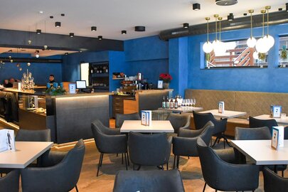 A modern, cozy bistro with blue walls and elegant decor.