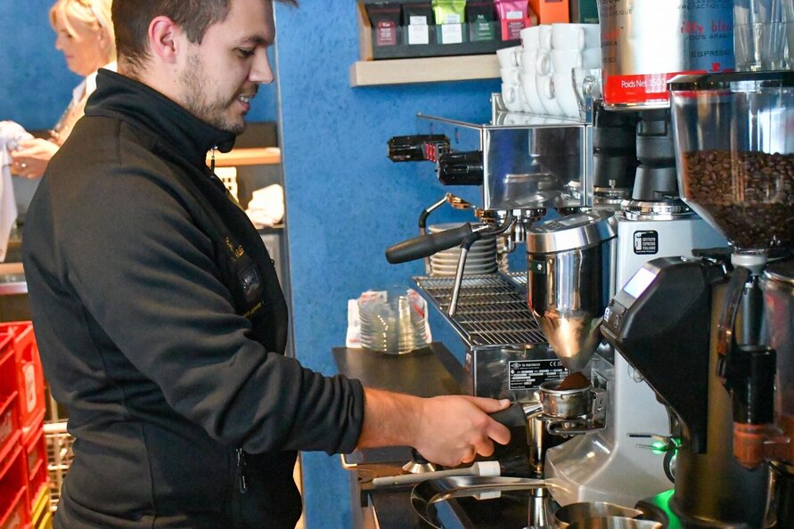 Ein Barista bereitet im Bistro Mila Kaffee zu.