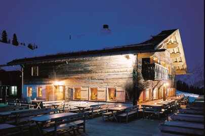 Illuminated Rud Alpe with benches at night.