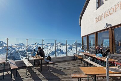 Aussichtsplattform des Rüfikopf Restaurants mit Blick auf verschneite Berge.