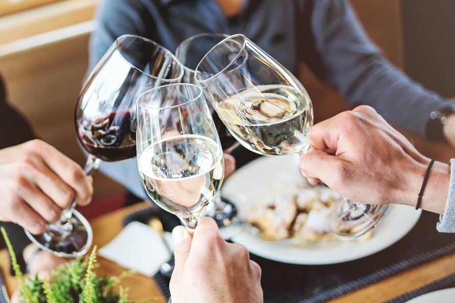 Personen stoßen mit Weingläsern im Seekopf Restaurant an.