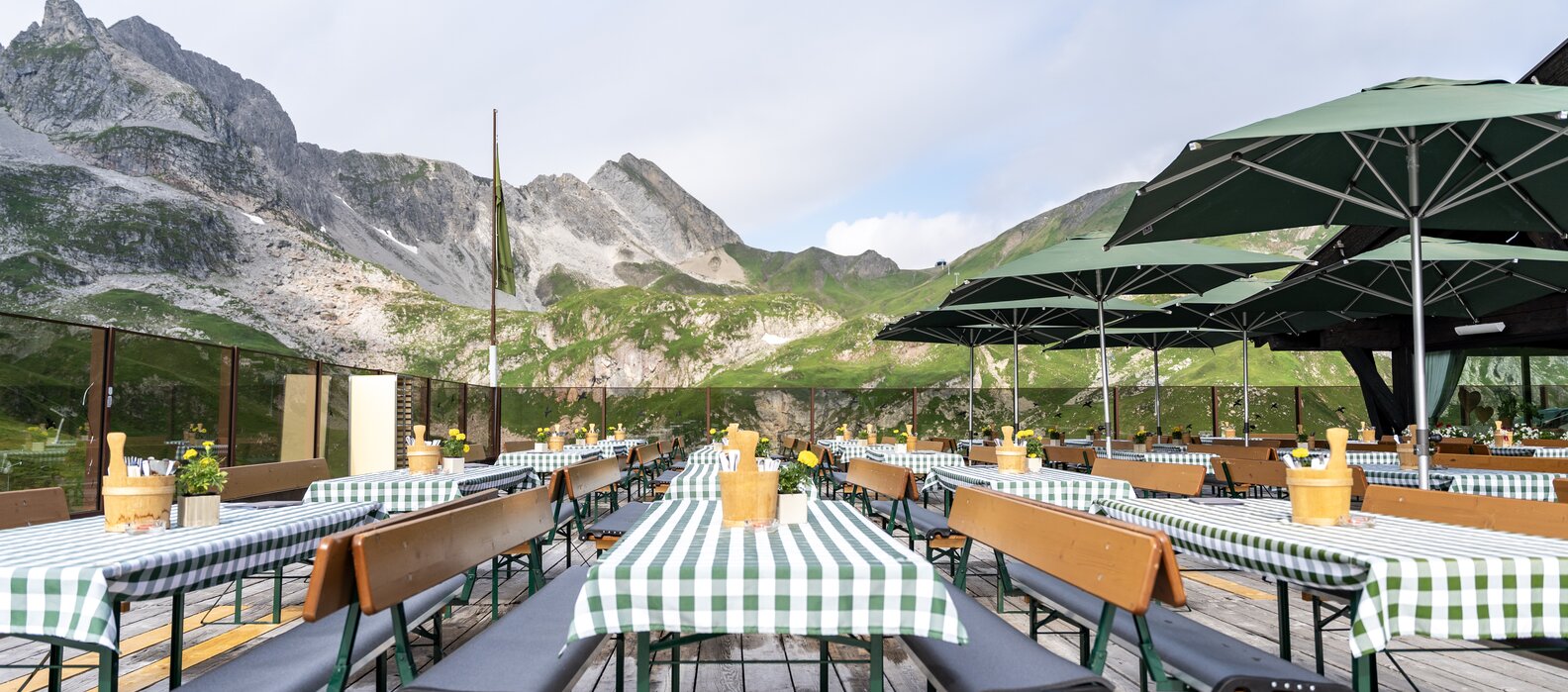 Outdoor terrace of the Seekopf Restaurant with mountain view and umbrellas