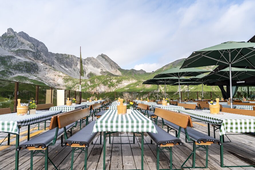 Außenterrasse des Seekopf Restaurants mit Bergblick und Sonnenschirmen