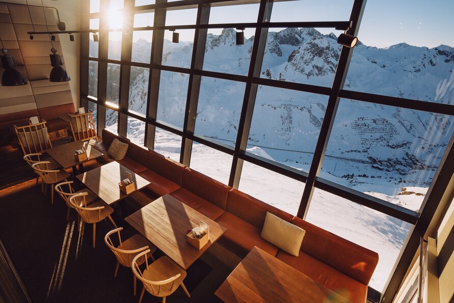 Beeindruckende Panoramaglasfront in der Trittkopf BBQ Station gewährt Blick auf schneebedeckte Berge.