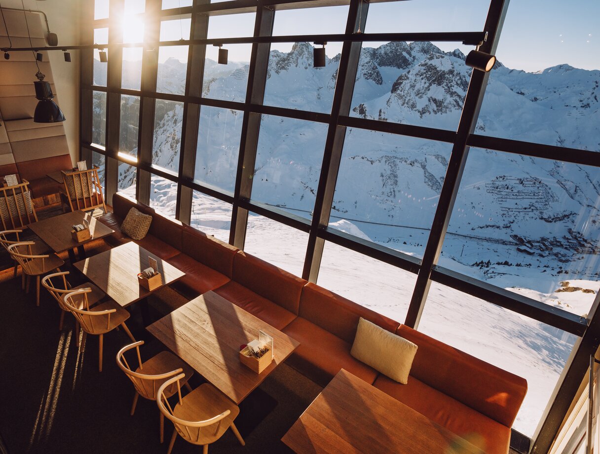 Beeindruckende Panoramaglasfront in der Trittkopf BBQ Station gewährt Blick auf schneebedeckte Berge.