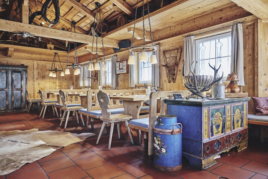 Das Restaurant Trittalpe mit Holztischen, Bänken und rustikalem Dekor.
