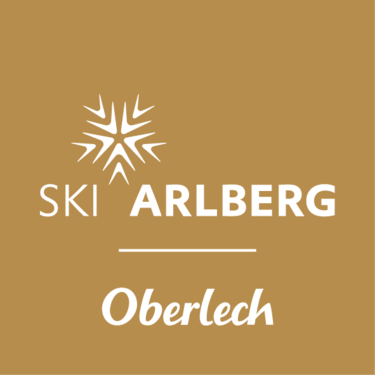 Logo von Ski Arlberg mit Schriftzug Oberlech auf braunem Hintergrund.