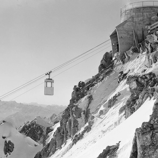 A cable car glides above a snow-covered mountainside.