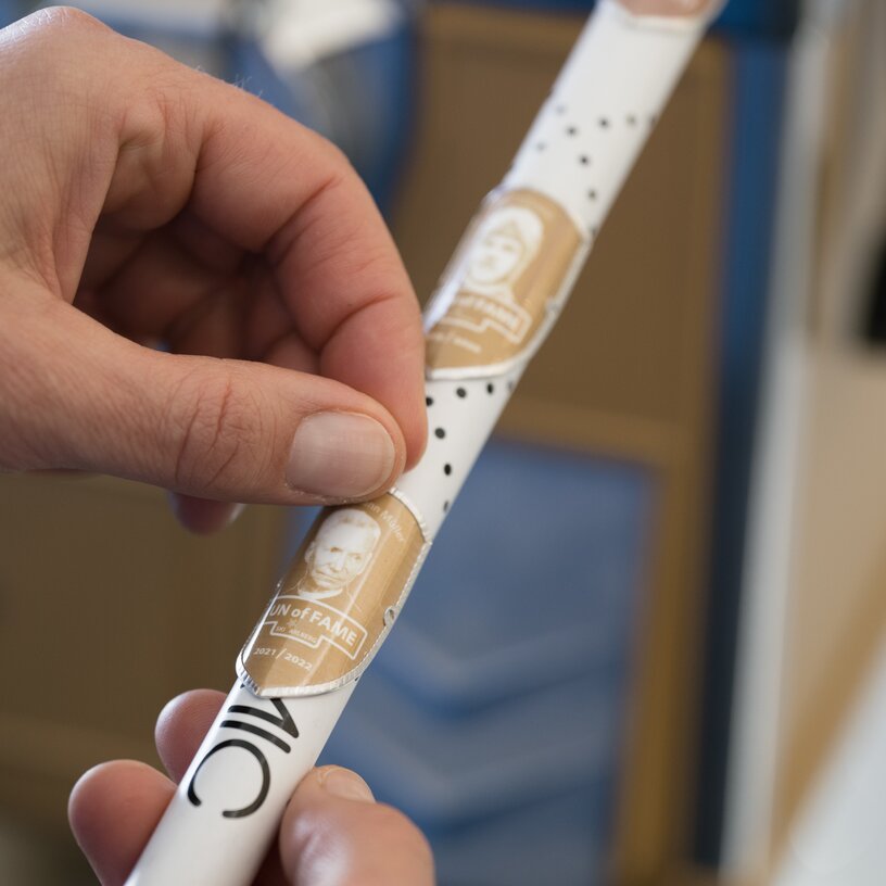 A 'Run of Fame' sticker is applied to a hiking stick.