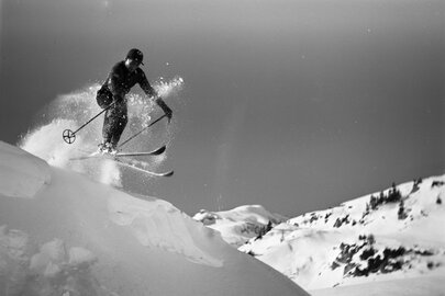 Skier jumps over a snow edge with an impressive pose.