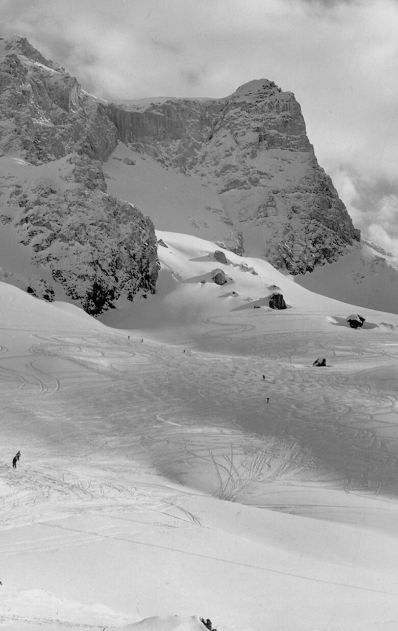 Skiers enjoy fresh powder on a snowy mountain slope.