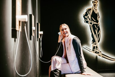 Frau bedient Audioguide im Skimuseum.