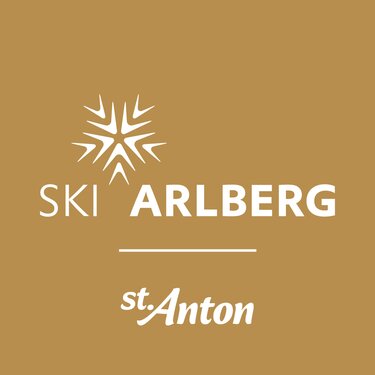 The logo of Ski Arlberg St. Anton on a golden background.