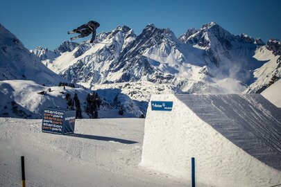 Ein Freestyle-Skifahrer springt im stanton park am Rendl über einen Kicker.