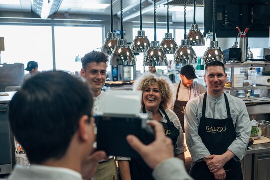 3 Personen von der Küchencrew der Galzig Bistrobar posieren für ein Foto in der Küche.