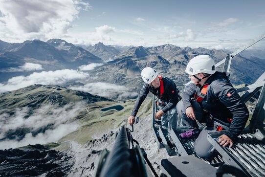 Zwei Männer führen im Sommer eine technische Überprüfung einer Seilbahnanlage in St. Anton durch.