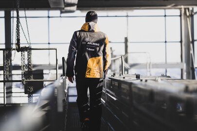 Person in Ski Arlberg Jacke geht durch eine moderne Anlage.