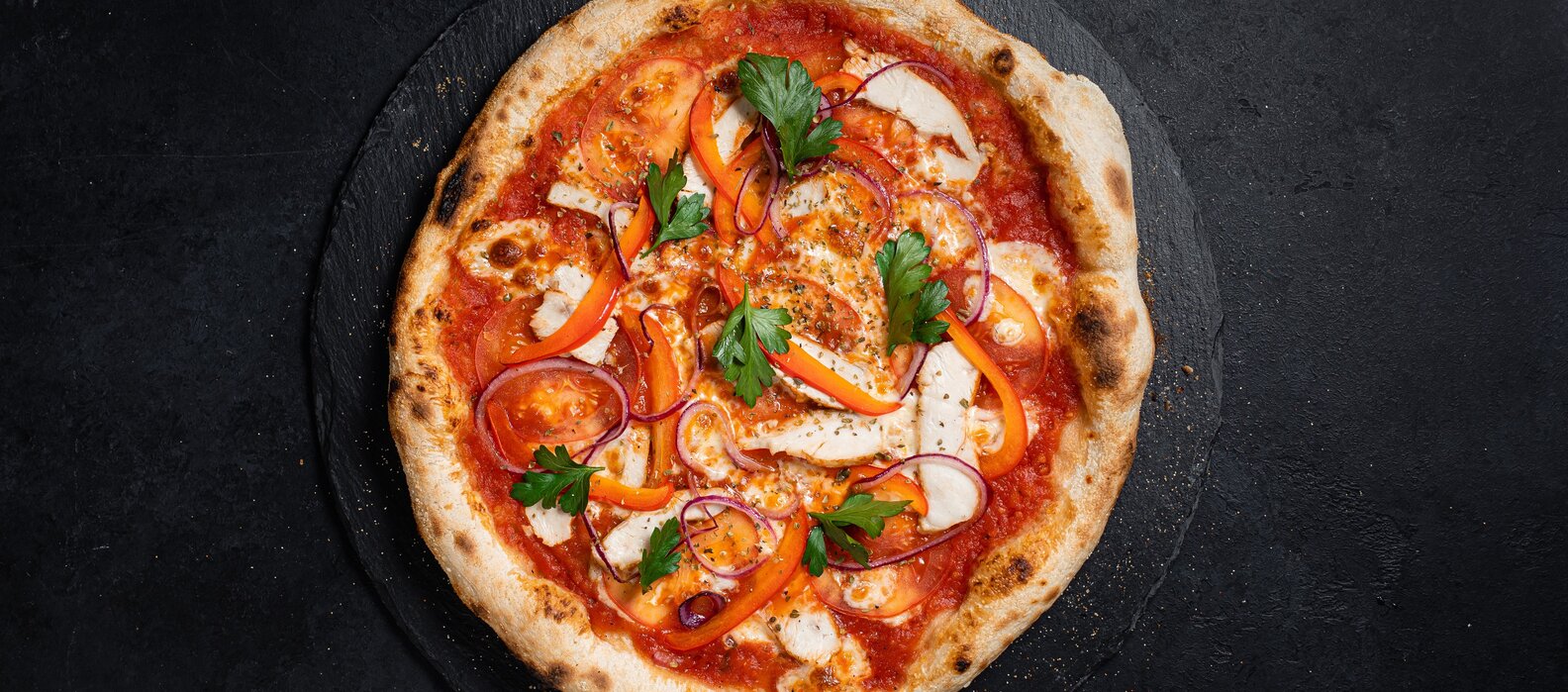 Handgemachte Pizza mit Tomaten, Paprika, Zwiebeln und Petersilie.